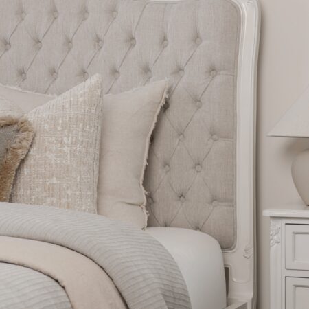 Alice French Provincial Bed with an antique white carved frame and neutral button-tufted upholstery