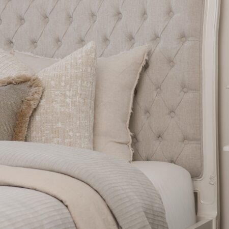 Alice French Provincial Bed with an antique white carved frame and neutral button-tufted upholstery