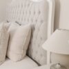 Alice French Provincial Bed with an antique white carved frame and neutral button-tufted upholstery